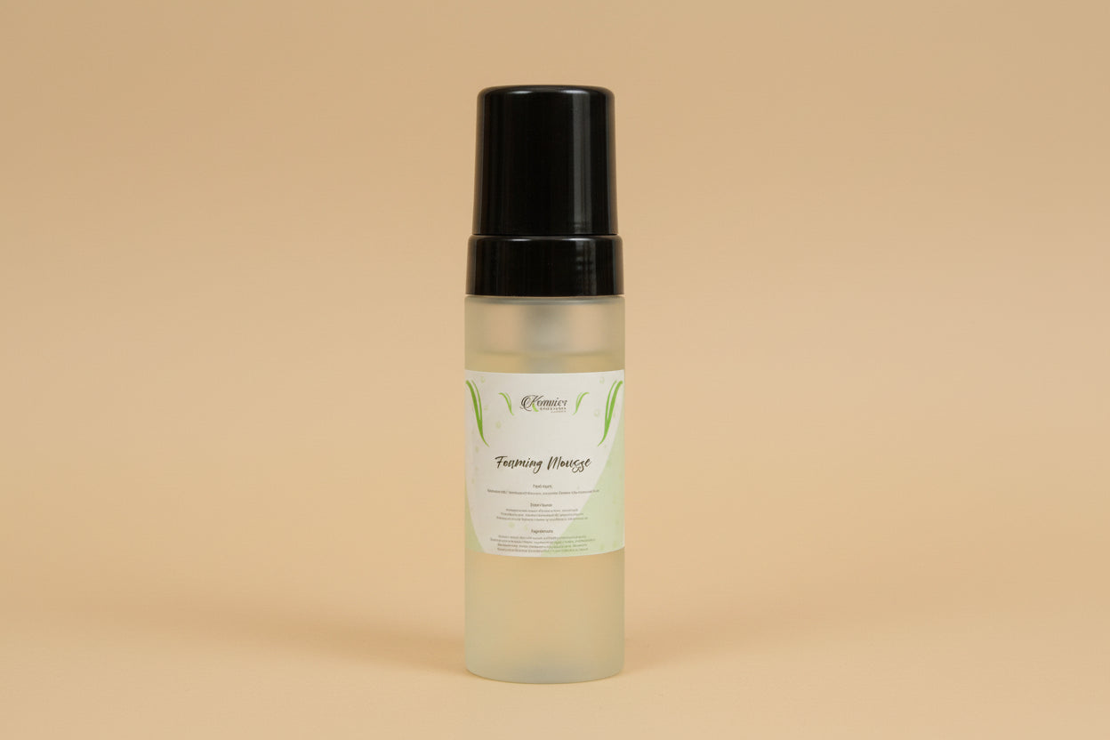 Skincare bottle with black cap and white label on a reflective surface with flowers in the background