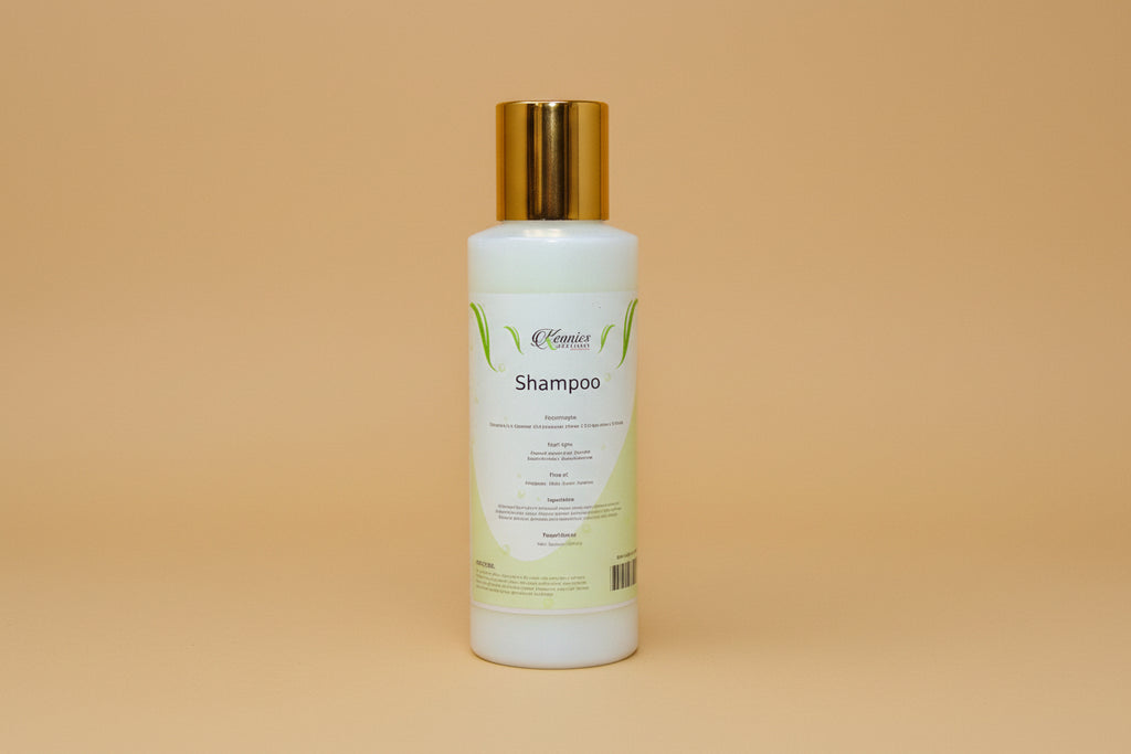 Three bottles of 'Kennies Creations' products on a wooden surface with a green leafy background